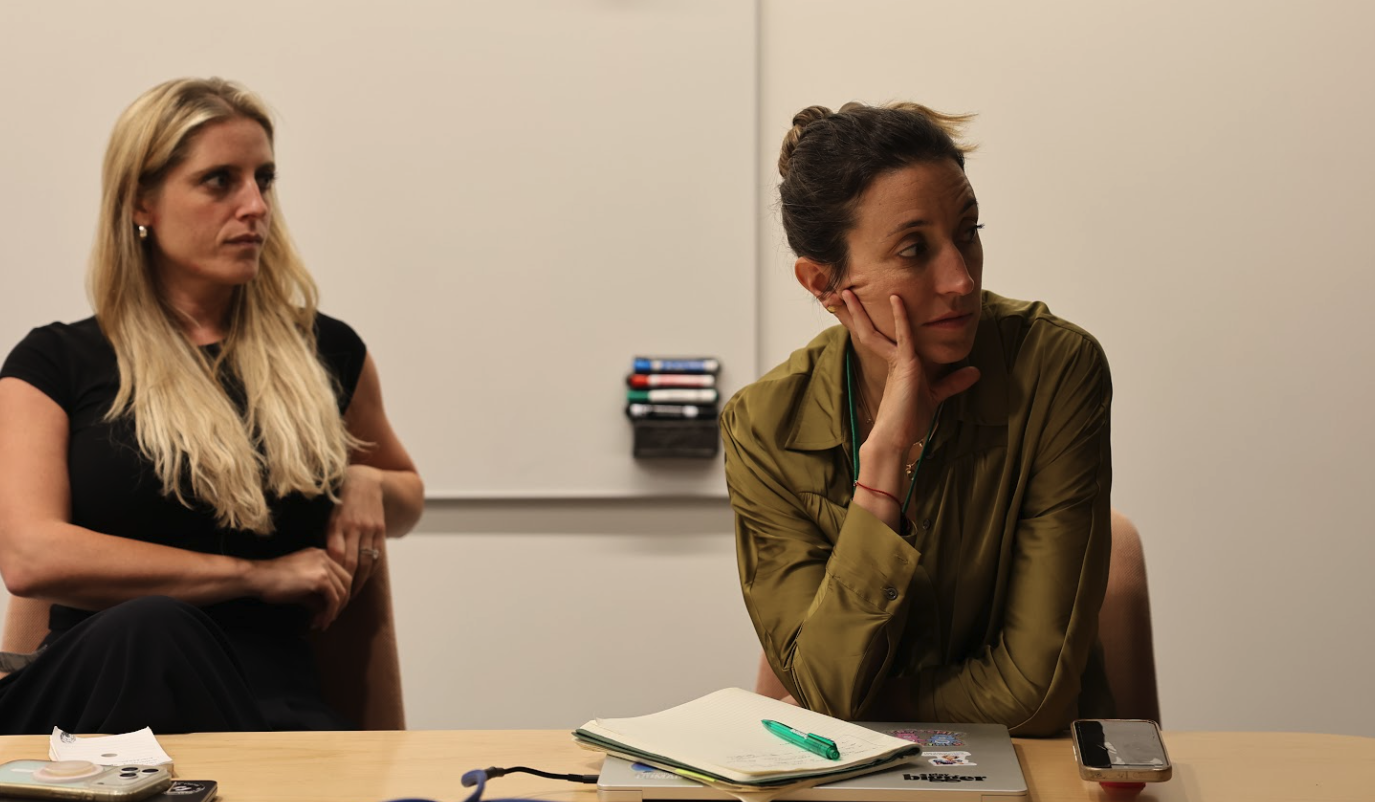 Charlotte and Thais seated at a whiteboard table during their first Techstars session
